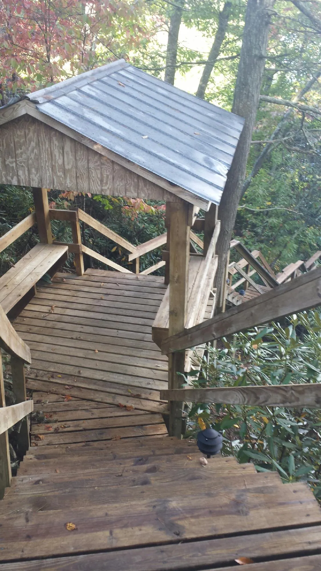 Metal roofed shelter over wooden steps on a wooded walkway — Skylight Repair & Installation work by our crew in Manville